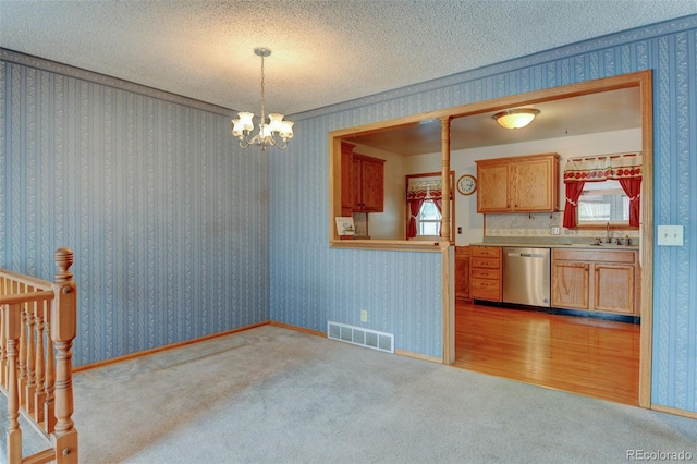 9766 Fillmore St, Thornton, CO 80229 - kitchen featuring dishwasher, a chandelier, light carpet, decorative light fixtures, and a textured ceiling
