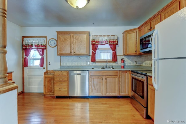 9766 Fillmore St, Thornton, CO 80229 - kitchen featuring stainless steel appliances, healthy amount of natural light, backsplash, and light wood finished floors