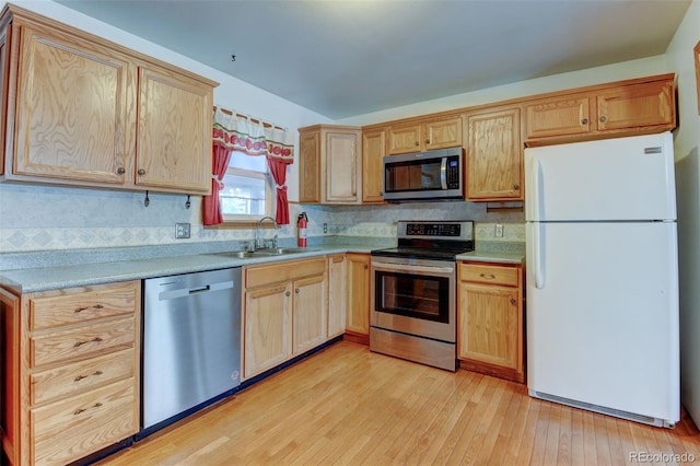 9766 Fillmore St, Thornton, CO 80229 - kitchen featuring appliances with stainless steel finishes, light wood finished floors, backsplash, light countertops, and light brown cabinetry