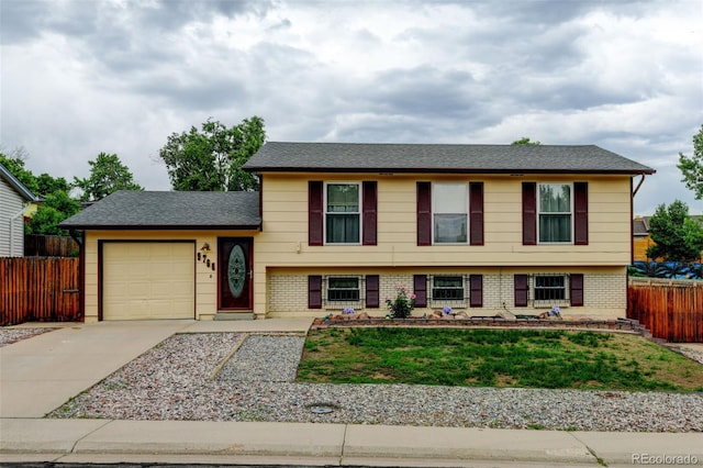 9766 Fillmore St, Thornton, CO 80229 - tri-level home featuring an attached garage, driveway, brick siding, and a shingled roof