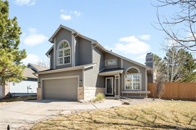 traditional-style home featuring fence, driveway, a chimney, a garage, and brick siding