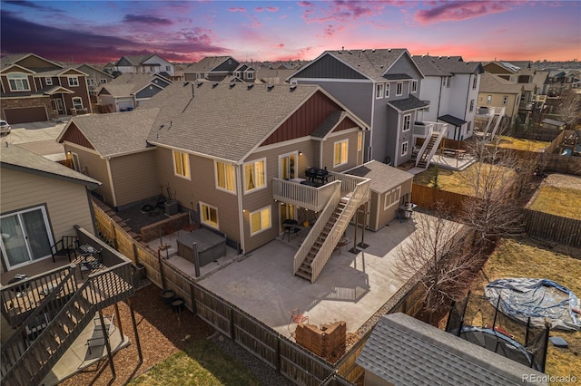 6817 Sequoia St, Frederick, CO 80530 - back of property at dusk featuring a residential view, board and batten siding, a deck, stairway, and a fenced backyard