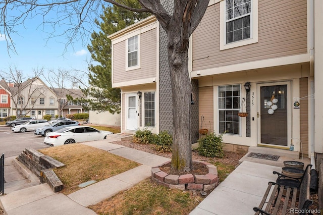 doorway to property featuring uncovered parking and a residential view