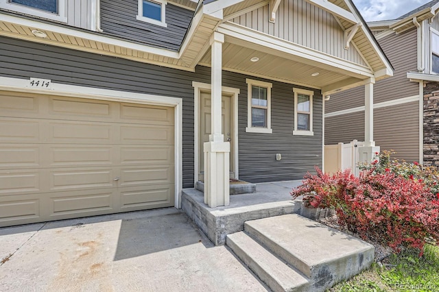 4414 Walden St, Denver, CO 80249 - view of exterior entry with board and batten siding, a garage, and a porch
