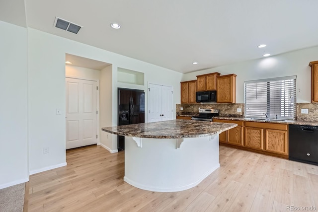 4414 Walden St, Denver, CO 80249 - kitchen featuring black appliances, brown cabinets, light wood-style floors, decorative backsplash, and recessed lighting
