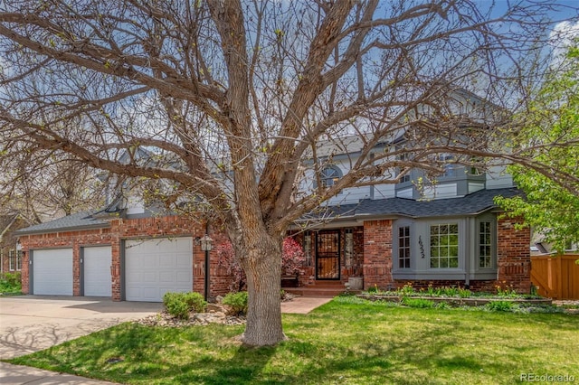 view of front of house featuring a garage, fence, a front lawn, brick siding, and driveway