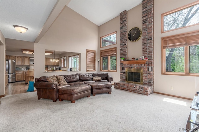living area featuring a high ceiling, a brick fireplace, light carpet, baseboards, and a chandelier