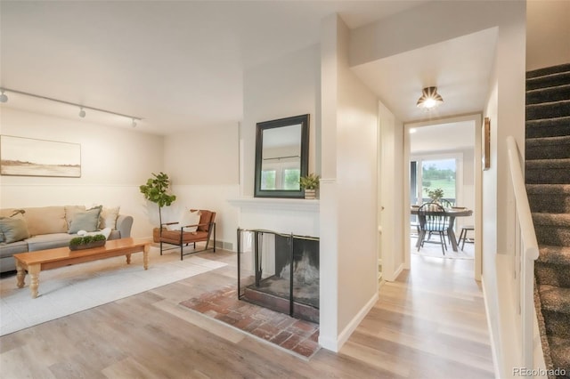 404 Raspberry Ln, Monument, CO 80132 - living room featuring stairway, wood finished floors, rail lighting, and a multi sided fireplace