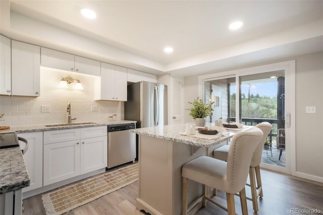 404 Raspberry Ln, Monument, CO 80132 - kitchen featuring stainless steel dishwasher, a sink, backsplash, light wood-style floors, and recessed lighting
