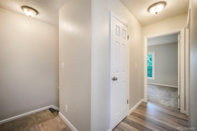 404 Raspberry Ln, Monument, CO 80132 - hall with a textured ceiling, wood finished floors, and baseboards