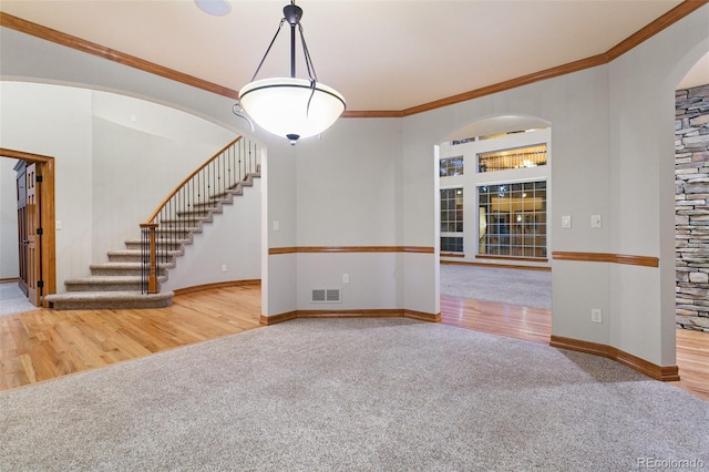 unfurnished living room featuring ornamental molding and carpet floors