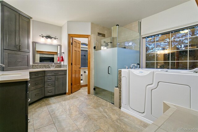 bathroom featuring tile flooring, shower with separate bathtub, and oversized vanity