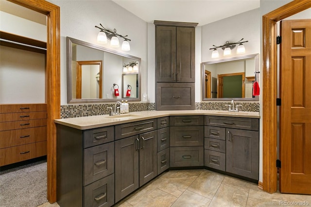 bathroom with tile floors, oversized vanity, tasteful backsplash, and double sink