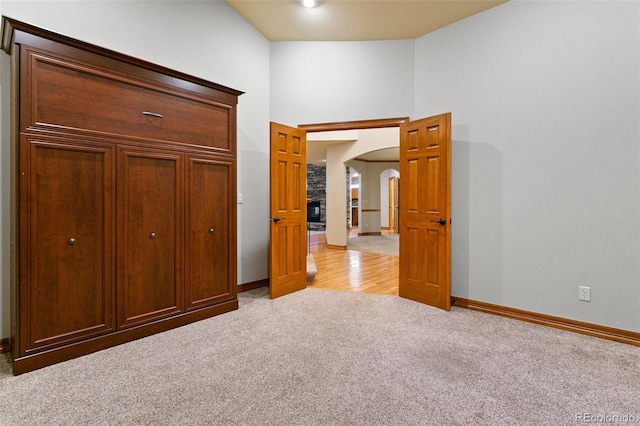 unfurnished bedroom featuring high vaulted ceiling and carpet