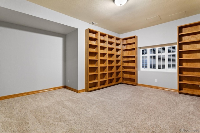 unfurnished room featuring carpet and a textured ceiling