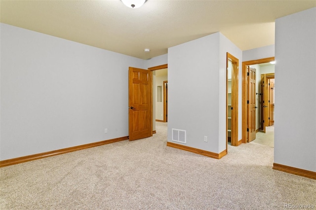 unfurnished bedroom featuring a closet and light colored carpet