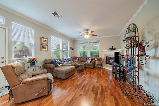 12856 King St, Broomfield, CO 80020 - living area with light wood-style flooring, crown molding, a fireplace, and a ceiling fan