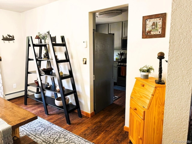 corridor with dark wood-type flooring, a baseboard radiator, and baseboards