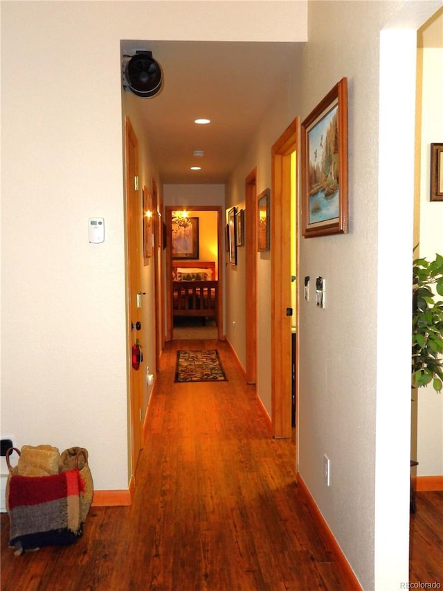 corridor with wood finished floors and baseboards