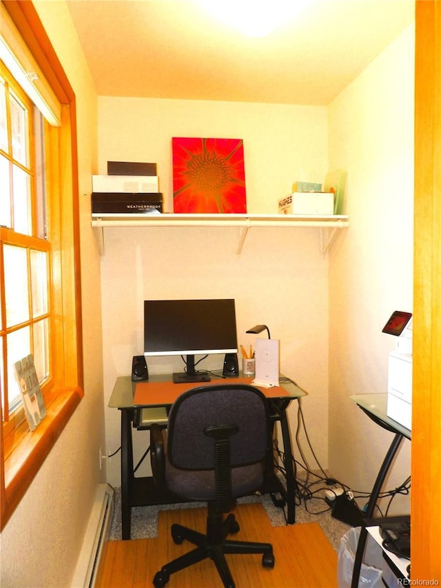 home office featuring a baseboard radiator and wood finished floors