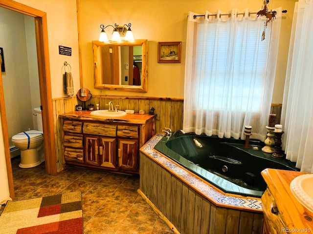 bathroom featuring tile patterned flooring, a tub to relax in, toilet, and vanity