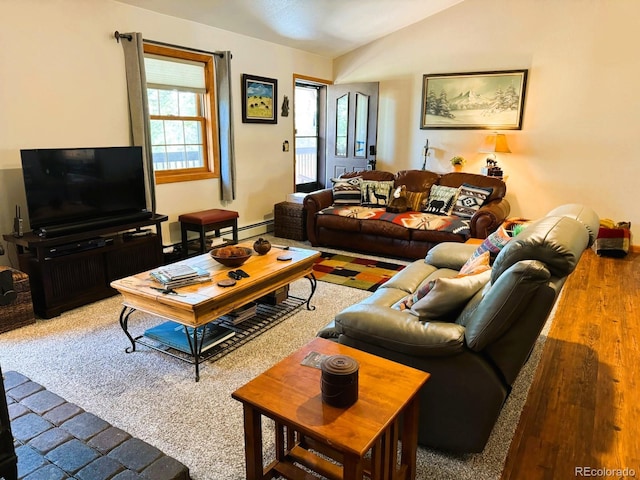 living room featuring lofted ceiling, baseboard heating, and carpet