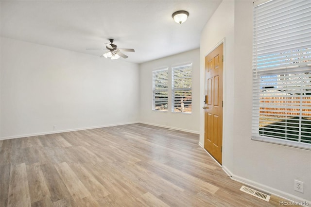 spare room with visible vents, ceiling fan, baseboards, and wood finished floors