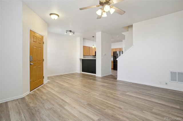 unfurnished living room featuring ceiling fan and light hardwood / wood-style floors