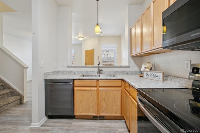 kitchen featuring light wood finished floors, light countertops, a sink, dishwasher, and stainless steel electric range