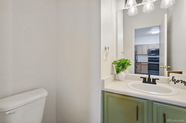 half bathroom with vanity and toilet