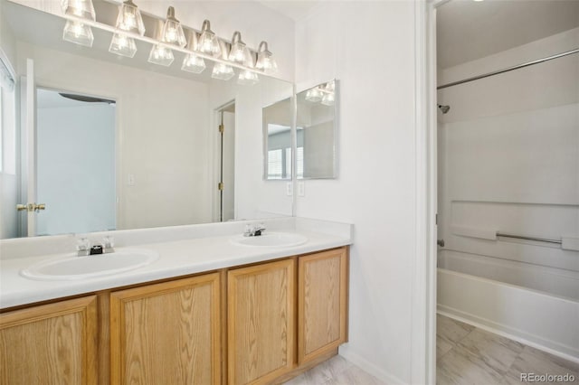 bathroom with double vanity, shower / tub combination, and a sink