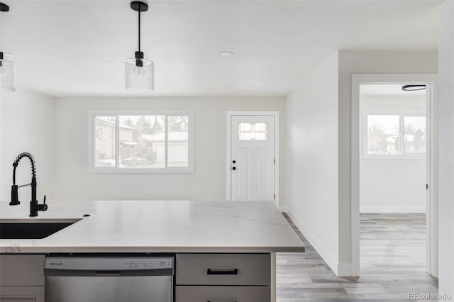 kitchen featuring sink, dishwasher, gray cabinetry, light stone countertops, and decorative light fixtures