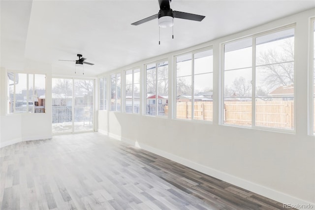 unfurnished sunroom with ceiling fan