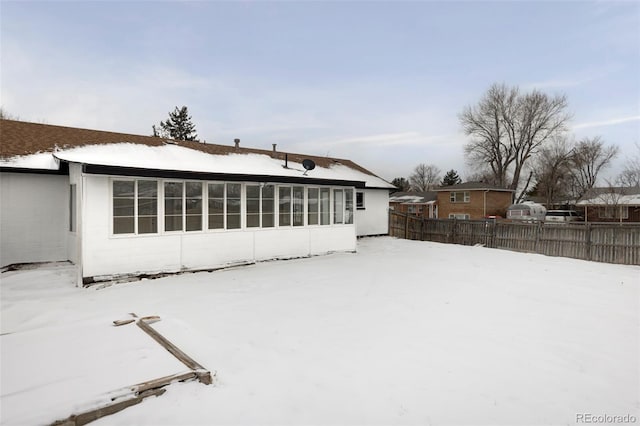 view of snow covered back of property