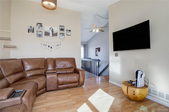 living room with light wood-type flooring, vaulted ceiling, and ceiling fan