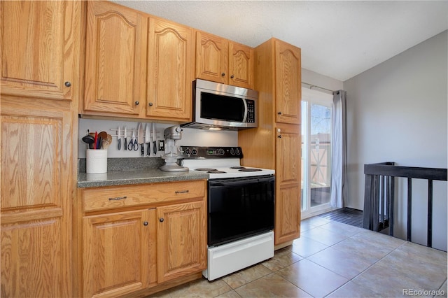 kitchen with light tile patterned floors and white range with electric cooktop