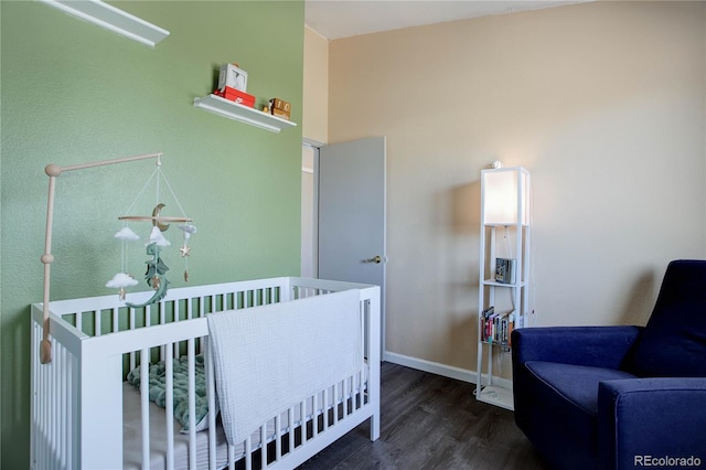 bedroom with a nursery area and dark wood-type flooring