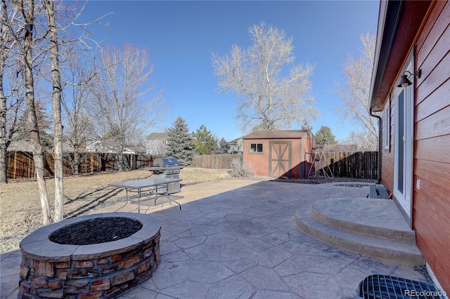 view of patio with a storage shed and an outdoor fire pit