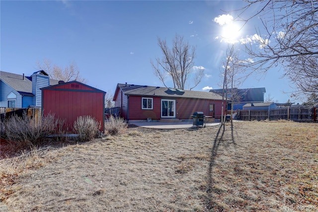 back of property featuring a shed and a patio area