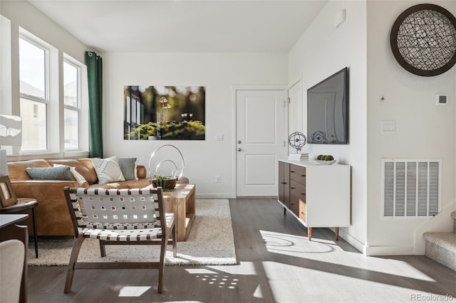 living room with visible vents, baseboards, and dark wood finished floors