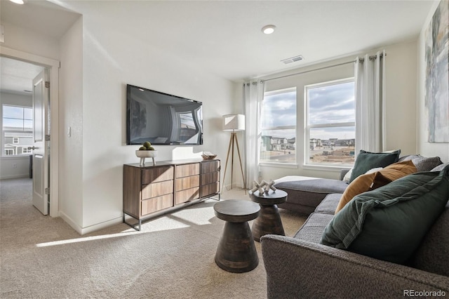 living room featuring light carpet, visible vents, and baseboards