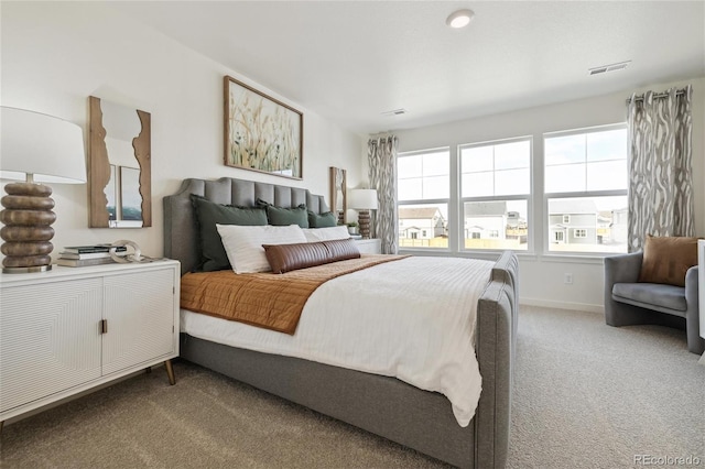 carpeted bedroom with visible vents and baseboards