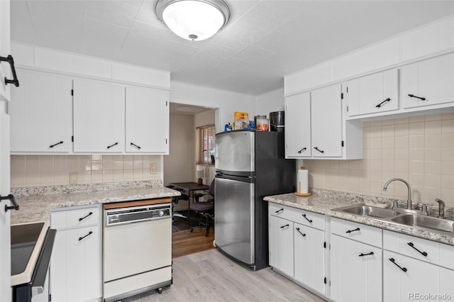6627 Eaton St, Arvada, CO 80003 - kitchen featuring dishwasher, freestanding refrigerator, a sink, light wood-type flooring, and backsplash