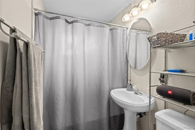 6627 Eaton St, Arvada, CO 80003 - full bathroom featuring toilet, a textured wall, and a shower with shower curtain