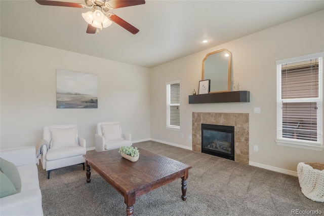 carpeted living room with a fireplace and ceiling fan