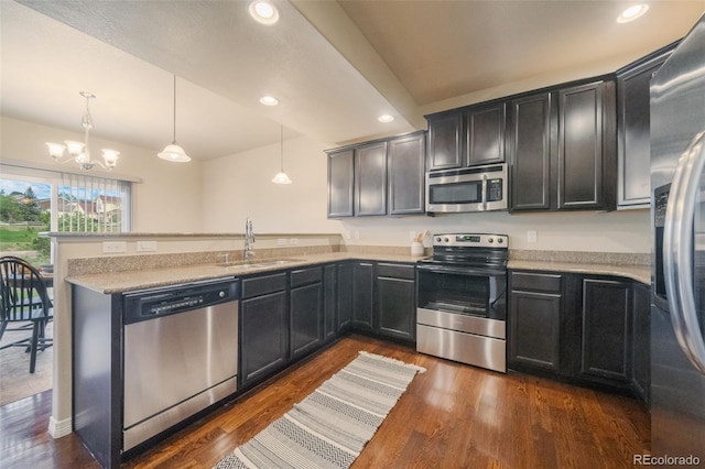 kitchen featuring dark wood-type flooring, hanging light fixtures, appliances with stainless steel finishes, and a chandelier