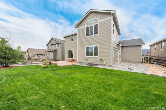 rear view of property featuring a lawn and a patio