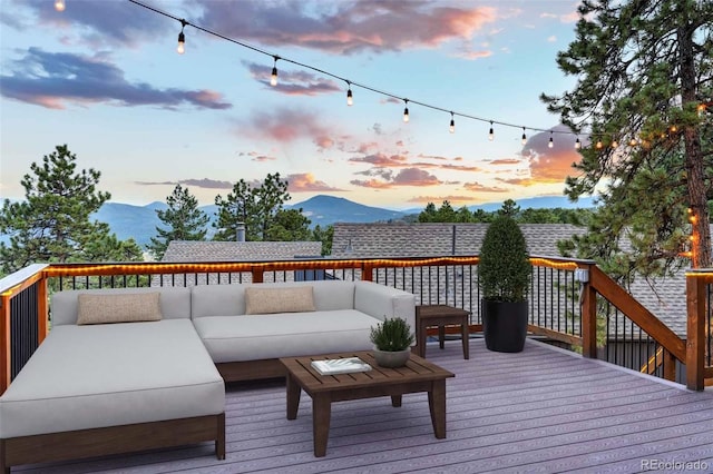 deck at dusk featuring outdoor lounge area and a mountain view