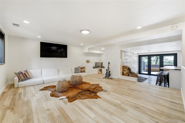 living area featuring baseboards, visible vents, wood finished floors, and french doors