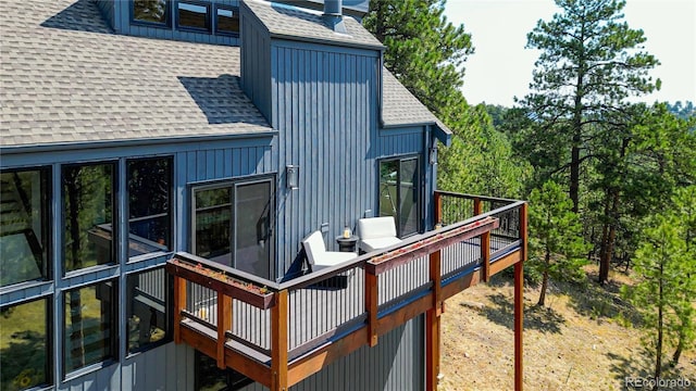 rear view of property with a shingled roof